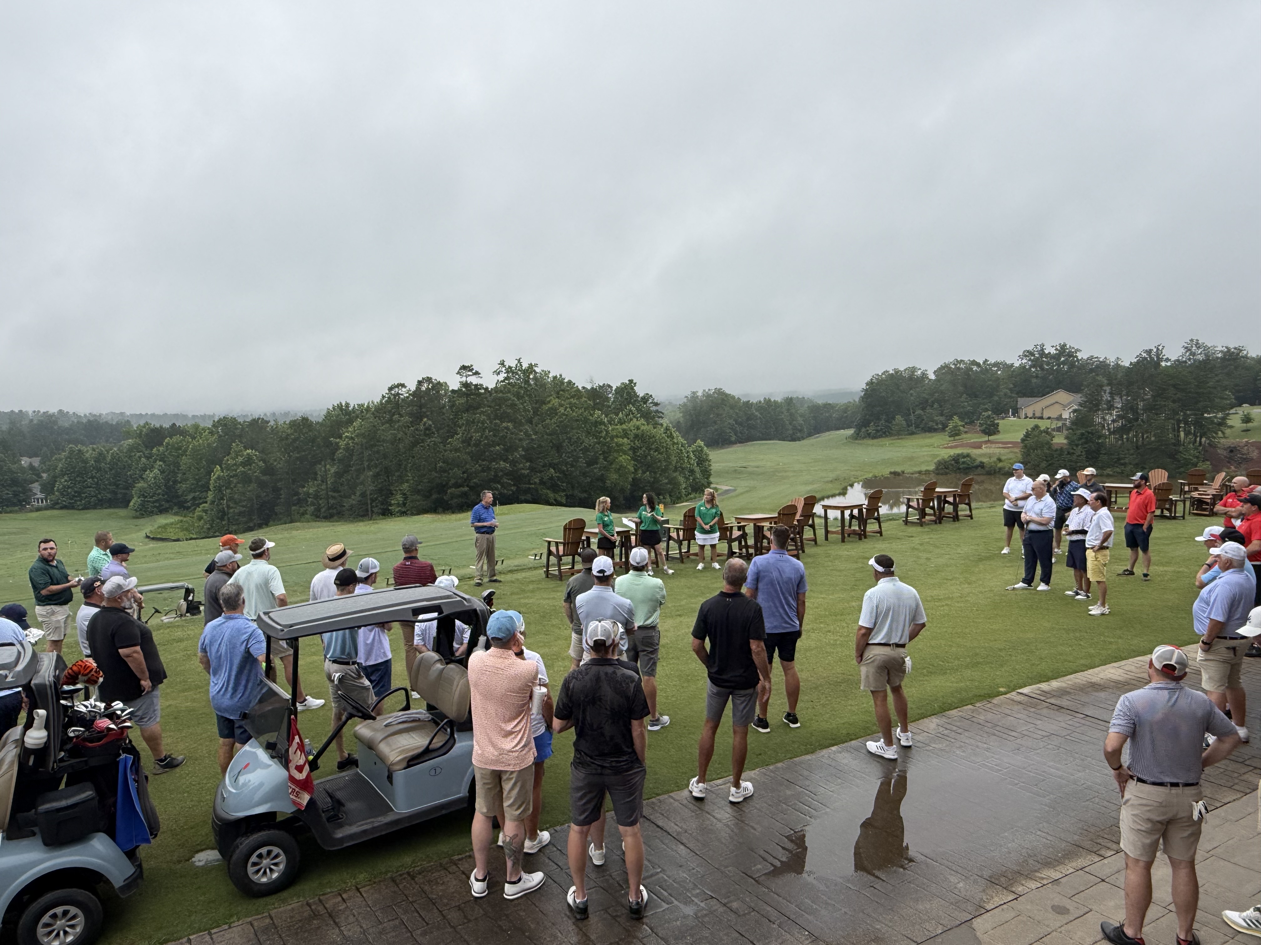 Golfers and organizers gathered on the clubhouse patio at Fairways of Canton on an overcast morning, listening to League volunteers in green shirts before the tournament tees off.